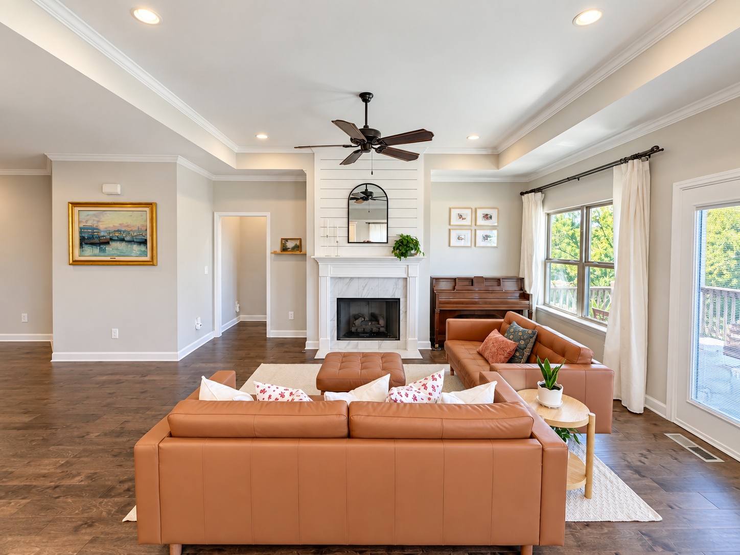 Great room with tray ceiling, recessed lighting, hardwood floors, and a shiplap fireplace wall
